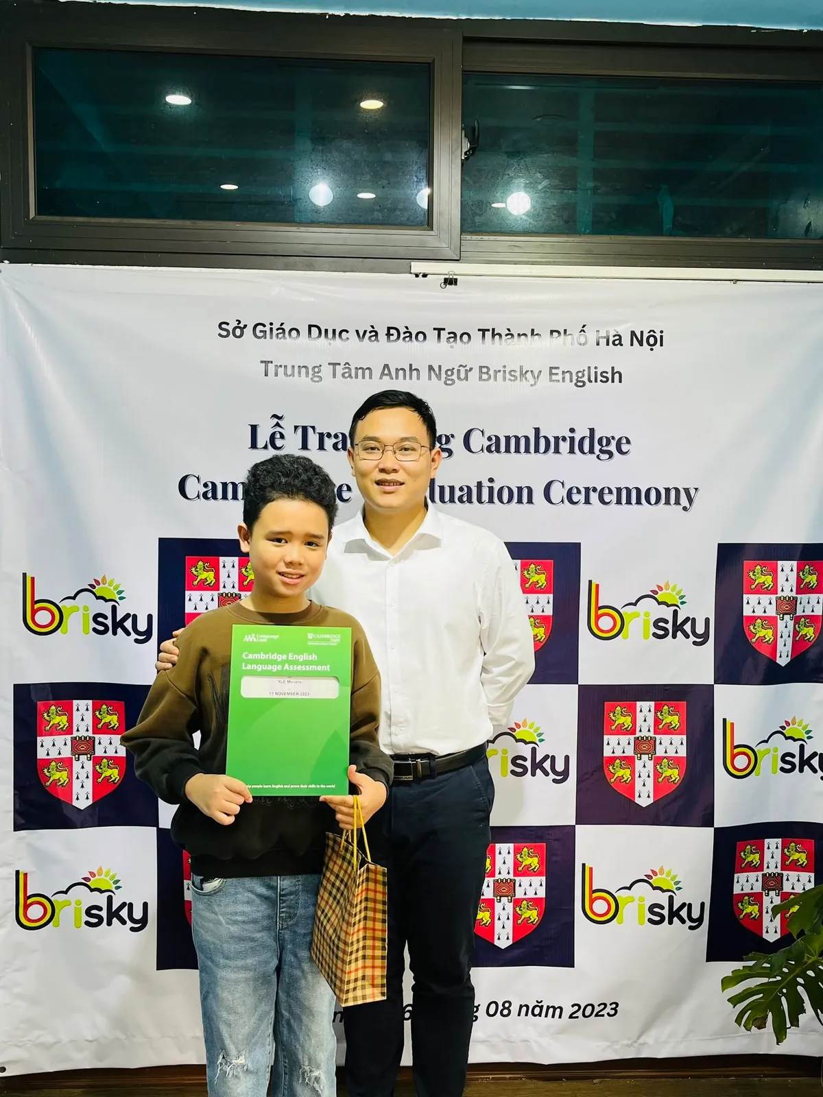 Học sinh Brisky cầm chứng chỉ Cambridge cùng thầy Quyền